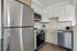 Modern kitchen with sleek stainless steel appliances, elegant tile backsplash, and stylish wood cabinetry.