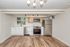 Modern kitchen with sleek stainless steel appliances, stylish wooden cabinetry, and elegant lighting fixtures, featuring a large window for natural light.