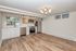 Modern kitchen with sleek cabinetry, stainless steel appliances, and elegant wood flooring, accentuated by contemporary lighting.