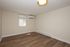 Modern, spacious room with sleek wooden flooring, large window, and built-in air conditioning, ideal for a serene living space.