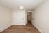 Modern, spacious room with elegant wooden flooring, bright lighting, and sleek sliding closet doors.