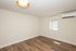 Bright and spacious room with elegant wood flooring, modern lighting, and natural light streaming through the window.
