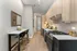 Contemporary kitchen with sleek appliances, elegant wooden cabinetry, and a cozy breakfast bar featuring modern seating.