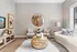 Chic and cozy living room featuring elegant furniture, a stylish round mirror, and a modern wicker coffee table with decorative accents.