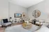 Modern living room featuring chic decor, plush seating, large wall mirror, and a stylish wooden TV unit, creating a cozy yet elegant ambiance.