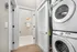 Modern apartment hallway featuring an elegant laundry area with stacked Samsung washer and dryer next to a pristine bathroom.