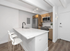 Modern kitchen with elegant white marble countertop, sleek black faucet, and stainless steel appliances, featuring minimalist wooden cabinetry and stylish bar stools against a bright interior.