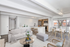 Bright and inviting open-concept living space with modern kitchen, cozy seating area, and stylish dining spot featuring large windows.