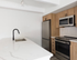 Modern kitchen with sleek marble countertops, stainless steel appliances, and stylish wooden cabinets.