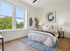 Bright and contemporary bedroom with large windows, elegant decor, and inviting bedding, perfect for relaxation.