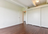Chic and minimalistic room with rich wooden floors and ample closet space, perfect for personalization.