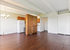 Spacious open-concept living area with rich hardwood floors, modern kitchen cabinetry, and elegant overhead lighting.