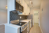 Chic kitchen with modern appliances, stylish hexagonal backsplash, and sleek wood flooring.