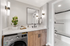 Chic bathroom featuring a modern vanity with black fixtures, integrated washer, and stylish lighting.