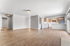 Spacious open-plan living area with elegant wooden flooring, modern kitchen with stainless steel appliances, and abundant natural light.