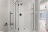 Bright, modern bathroom featuring a sleek glass-enclosed shower with matte black fixtures and abundant natural light.
