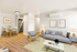 Chic modern living room with a gray sofa, stylish decor, and an open dining area featuring a wooden table and contemporary chairs.