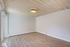 Spacious room with elegant wood flooring, natural light, and modern ceiling design.