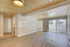 Bright and spacious living room featuring elegant wooden ceilings, modern flooring, and large sliding glass doors leading to a private patio.