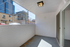 Charming outdoor balcony with modern lighting, offering a view of the cityscape and neighboring buildings.