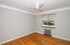 Bright and airy room with hardwood floors, modern ceiling fan, and large window offering scenic outdoor views.