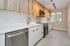 Modern kitchen with sleek stainless steel appliances, elegant quartz countertops, and stylish wood cabinetry.