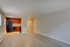 Modern open-concept apartment with sleek wooden flooring, cozy kitchen featuring dark wood cabinets, and bright natural lighting.