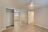 Bright and airy bedroom with mirrored sliding closet doors, sleek ceiling fan, and elegant wood flooring.