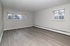 Bright and airy empty room with large windows, sleek gray flooring, and neutral wall colors, ideal for modern living.