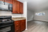 Modern kitchen with elegant wood cabinets, sleek black appliances, and granite countertops, offering a glimpse into a bright, spacious living area.