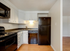 Modern kitchen with sleek black appliances, white cabinetry, and hardwood floors, offering a stylish and efficient cooking space.