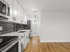 Modern kitchen with sleek white cabinetry, glossy hexagonal backsplash, and stainless steel appliances.