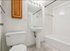 Bright and inviting bathroom with modern fixtures, featuring a sleek pedestal sink, classic bathtub, and elegant wood cabinet.