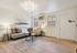 Bright and inviting living room with modern decor, featuring a cozy sectional sofa, stylish artwork, and a chic light fixture.