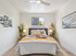 Inviting bedroom with modern decor, featuring a cozy bed, stylish artwork, and abundant natural light.