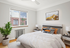 Bright and cozy bedroom with modern decor, featuring a large window, elegant bedding, and stylish bedside tables.