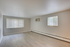Bright and spacious living area with large windows and modern wood flooring, perfect for cozy gatherings.