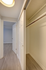 Inviting apartment hallway featuring elegant wood flooring and a spacious double-door closet.