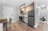 Modern apartment kitchen with stainless steel appliances, elegant wood cabinetry, and in-unit washer for convenient living.