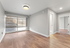 Bright and airy living space with large window, modern lighting, and elegant wood flooring.