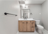 Modern bathroom with sleek wooden vanity, elegant mirror, and contemporary fixtures.
