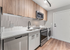 Modern kitchen featuring sleek stainless steel appliances, elegant wood cabinetry, and stylish track lighting.
