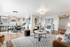 Bright and spacious open-concept living and dining area featuring modern decor, sleek kitchen with a breakfast bar, and cozy seating arrangement.
