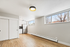 Bright apartment interior with modern kitchen, large windows, and hardwood flooring.
