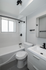 Sleek modern bathroom with a white bathtub, stylish fixtures, and bright natural lighting.