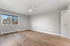 Bright and spacious bedroom with large window, modern ceiling fan, and elegant wood flooring.
