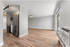 Modern open-plan apartment featuring sleek stainless steel appliances, airy living area, and elegant hardwood flooring.