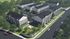 Aerial view of modern apartment complex with multiple buildings, green spaces, and parking areas.
