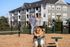 Apartment complex with a fenced dog park and playful dog catching a ball.