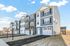 Contemporary townhomes in a serene community setting with spacious driveways and modern architecture.